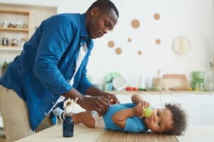 Man changing baby's diaper