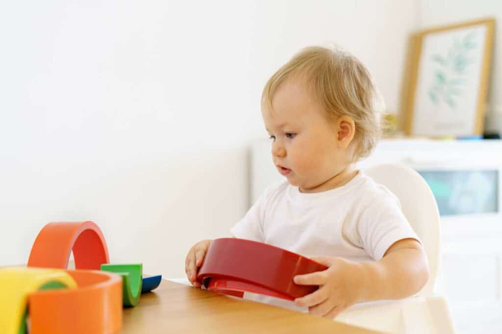 Toddler playing with puzzle toys using motor skills