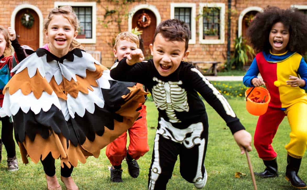 Kids laughing and running during a Halloween party