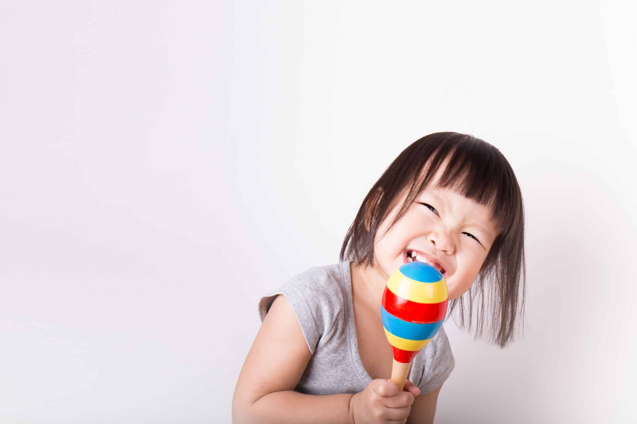 Toddler girl playing instrument in music class