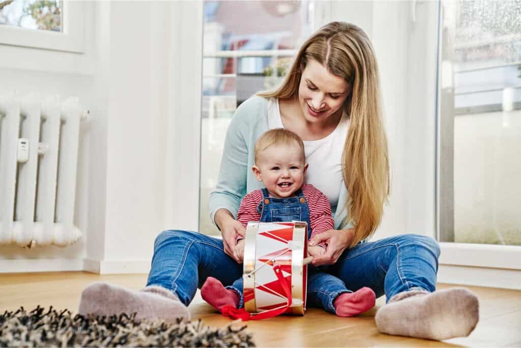 Baby playing drums with mom