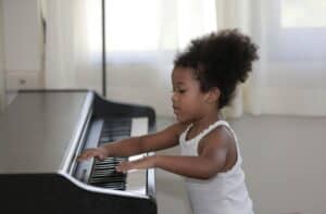 A little girl playing the piano in a living room.