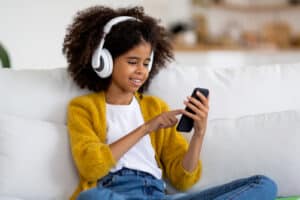 black child listening to music and watching iphone