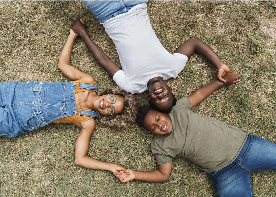A Home New Design archive showing a group of people laying on the grass in a circle.