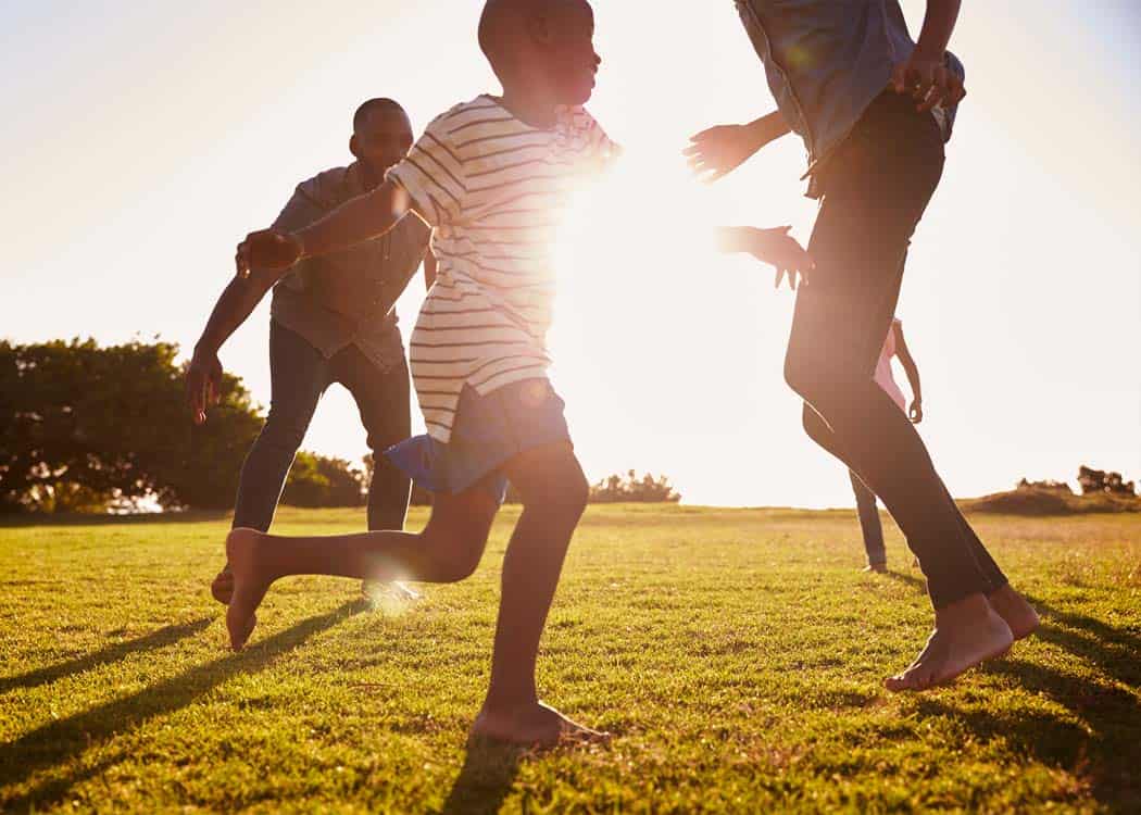 A family playing on a grassy field at sunset, captured in a beautiful archive photograph.