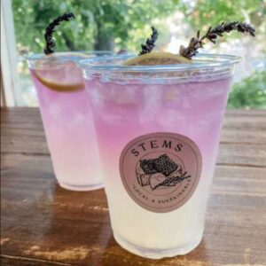 two cups of lavender lemonade on a wooden table