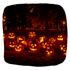 A group of carved pumpkins illuminated in a park at night, creating a spooky and enchanting atmosphere