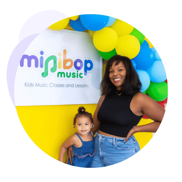 ceo of minibop with child in front of minibop sign banner with balloons