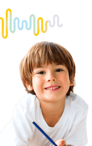 Preschool Homeschool Curriculum young boy smiling at the camera while writing