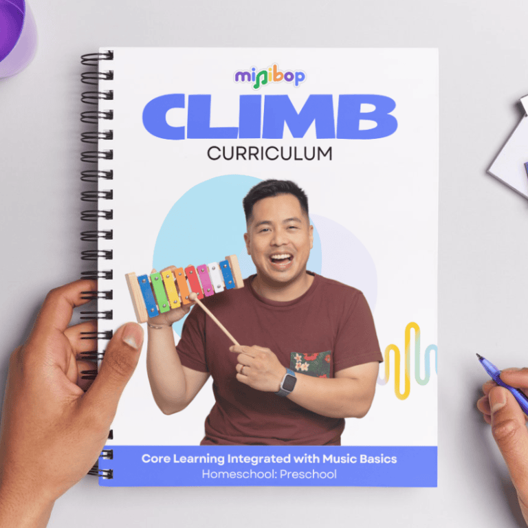 Hands holding a spiral notebook of the CLIMB Hub Curriculum